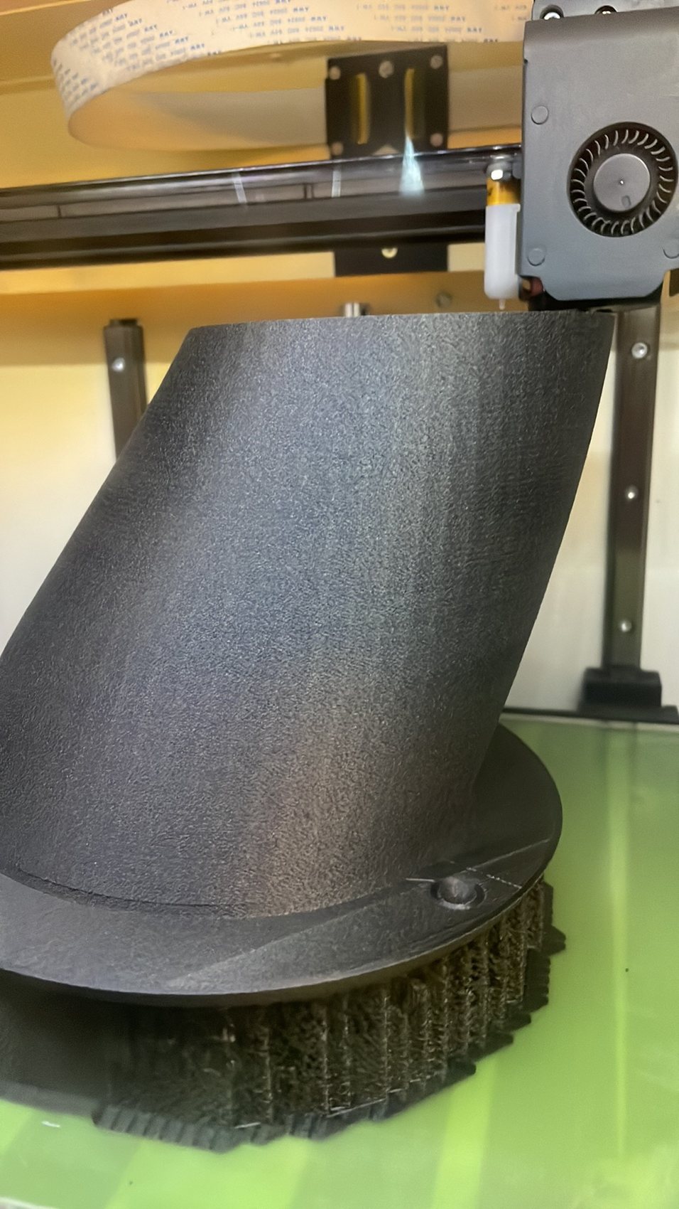 Black intake part being printed on a 3D printer