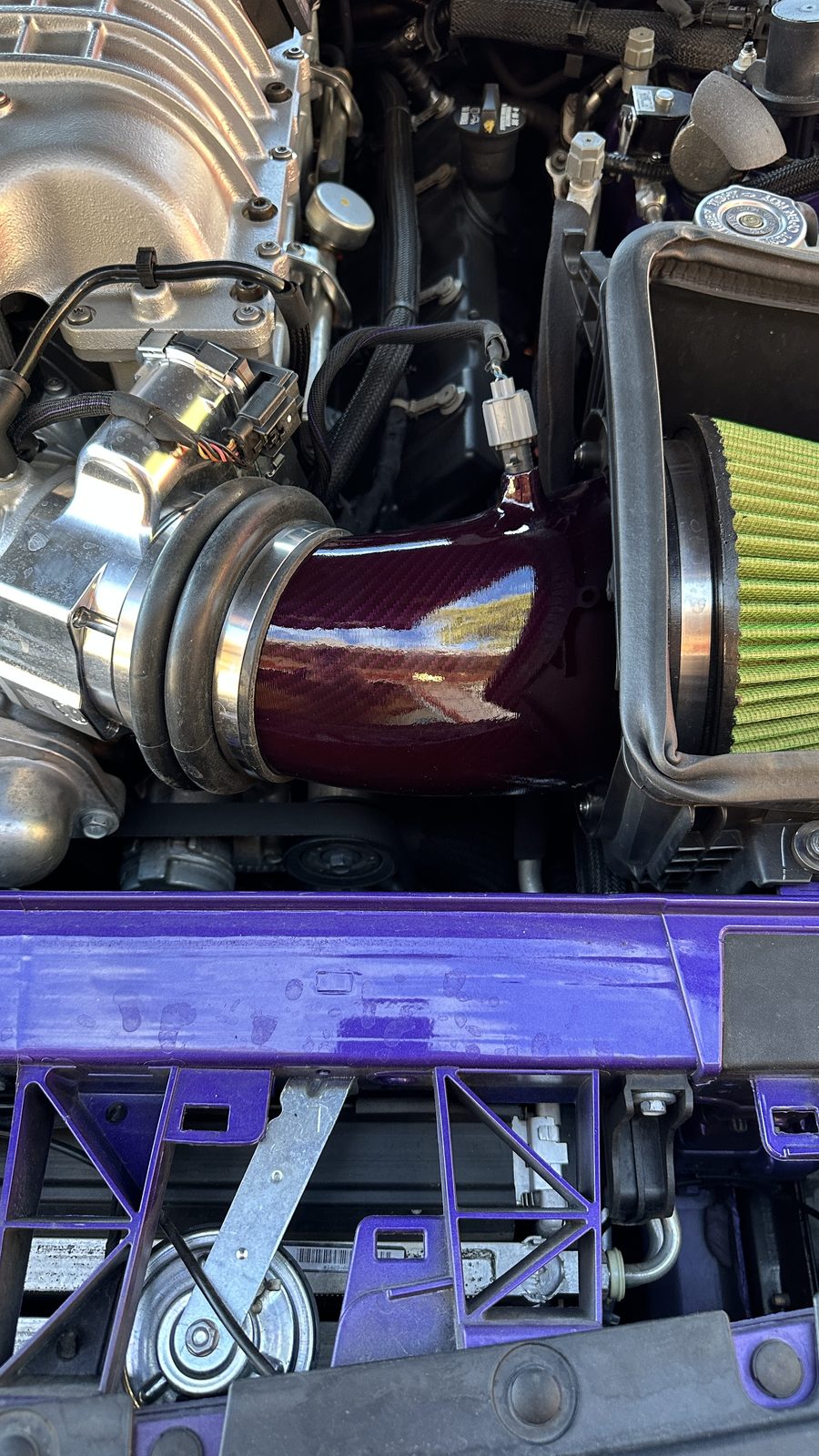 Purple intake tube and cone filter in an engine bay